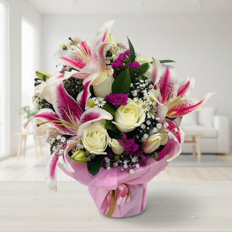 Crystal vase filled with pink lilies and white roses