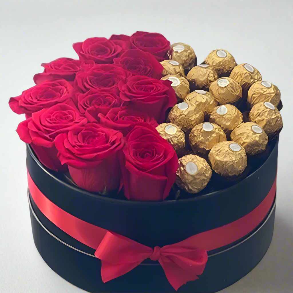Box with red roses and gold Ferrero Rocher chocolates on a reflective surface, Aroletes Antioquia