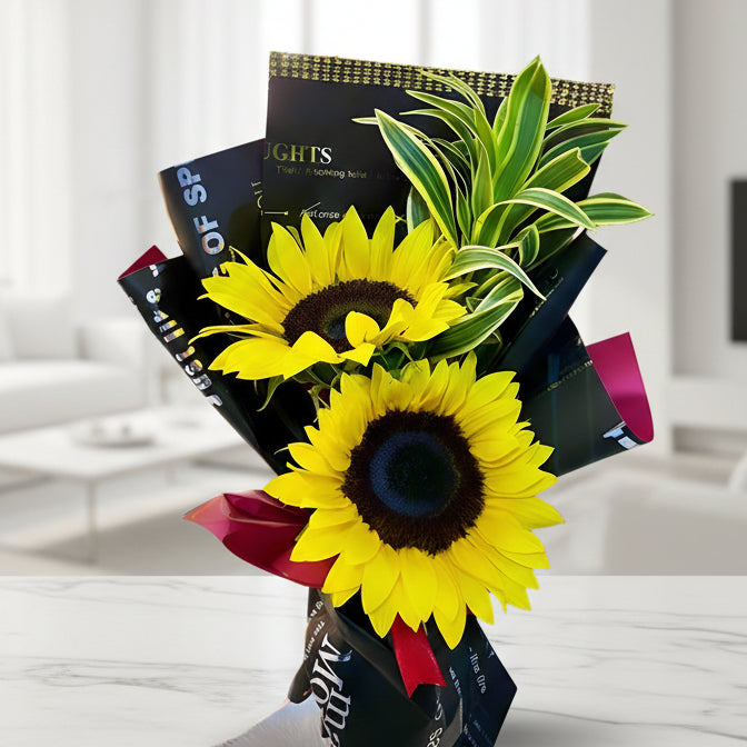 Bouquet with 2 bright sunflowers and greenery in black Korean paper wrap with red bow – delivery in Arboletes, Antioquia