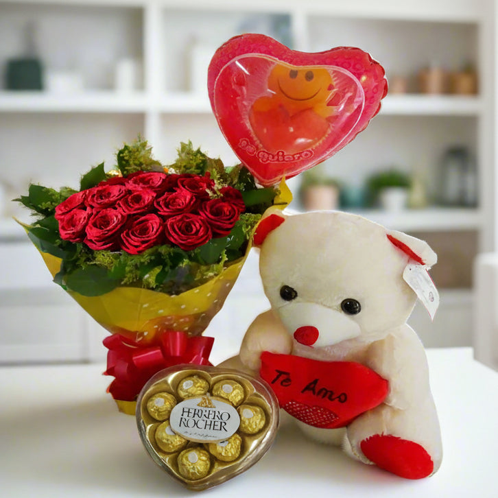 A romantic gift set featuring 12 red roses, an 11-inch teddy bear, a heart-shaped Ferrero Rocher chocolate box, and a 'Te Quiero' balloon, perfect for delivery in Colombia.