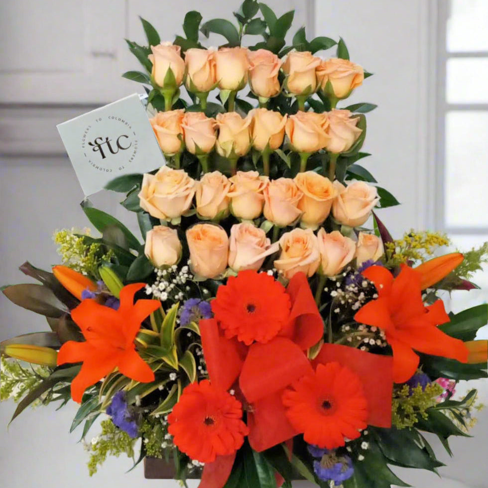 Floral arrangement with peach roses, orange lilies, and red gerberas in Armenia, Colombia – available for same day delivery.