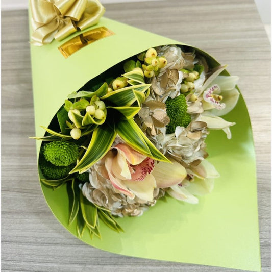 Elegant orchid and hydrangea bouquet wrapped in a green cone with a gold bow – Luxury flower delivery in Medellín