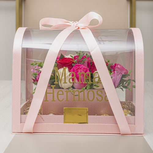 Pink luxury handbag-style box with roses, eucalyptus, Ferrero chocolates, and a personalized Mother’s Day ribbon for delivery in Medellín.