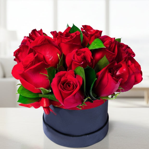 Red roses in round gift box with seasonal foliage - Bogotá and Medellín delivery
