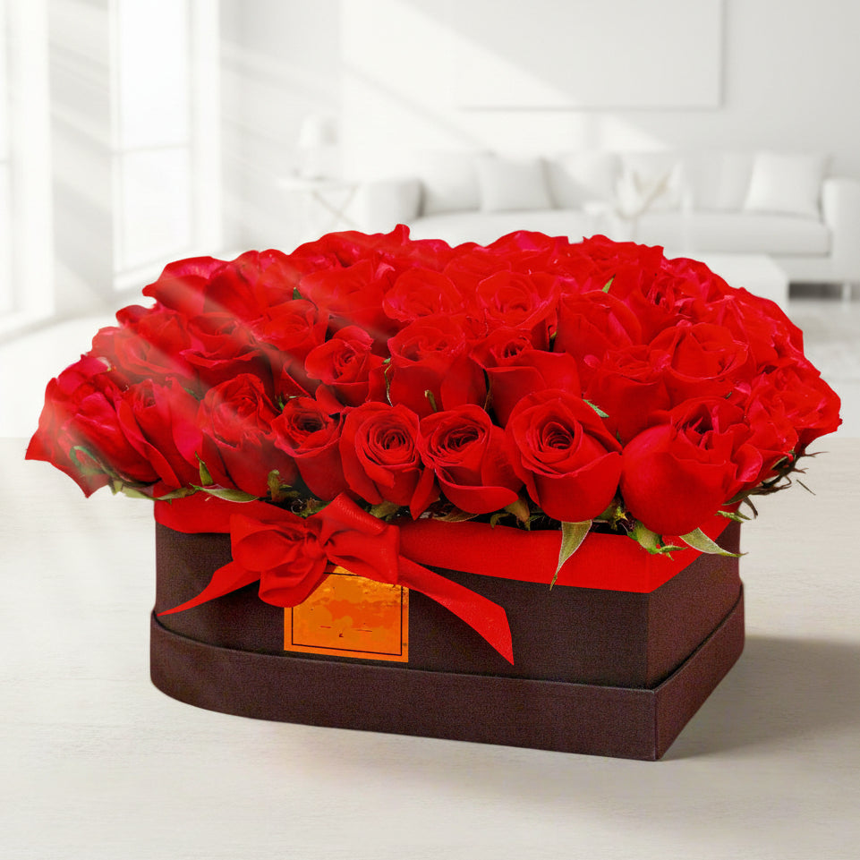 Luxury heart-shaped black box with 100 red roses arranged in a circular design, adorned with a red ribbon, perfect for Valentine’s Day in Medellín.