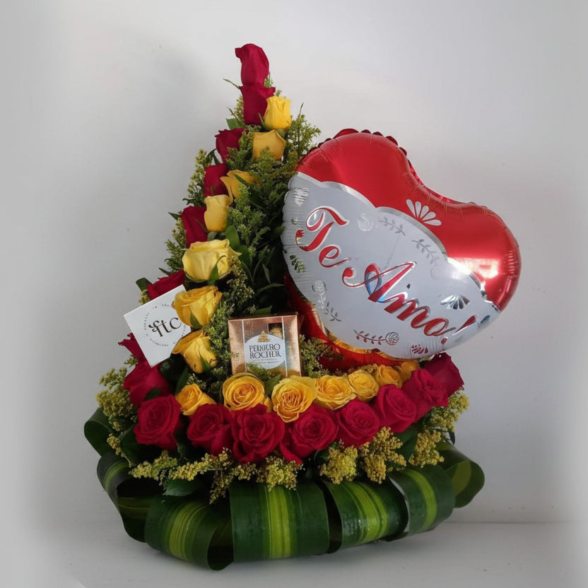 Heart-shaped arrangement of red and yellow roses with a 'Te Amo' balloon on a white background