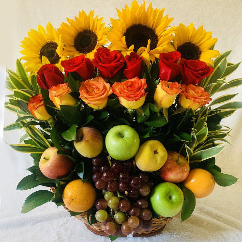 Beautiful basket with red and orange roses, sunflowers, and seasonal foliage, available for delivery in Bogotá, Medellín, and Cúcuta
