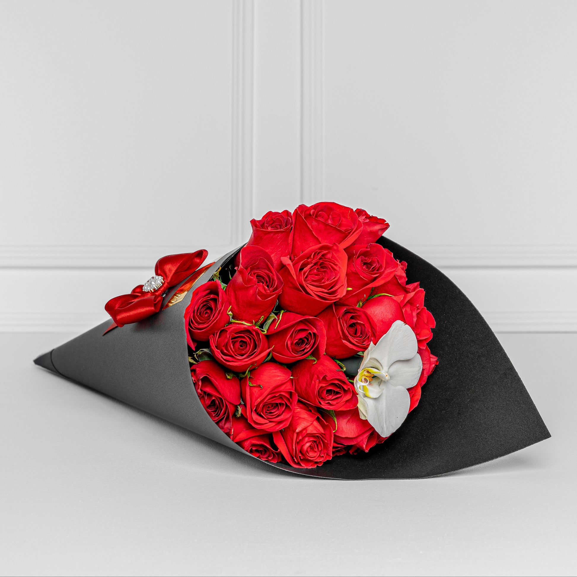 Luxury black cone with red roses and white orchid – elegant same-day flower delivery in Medellín.