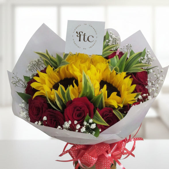 bouquet of vibrant sunflowers, red roses, baby’s breath, and greenery, wrapped with a stylish ribbon. Perfect for delivery in Cartago, Valle.
