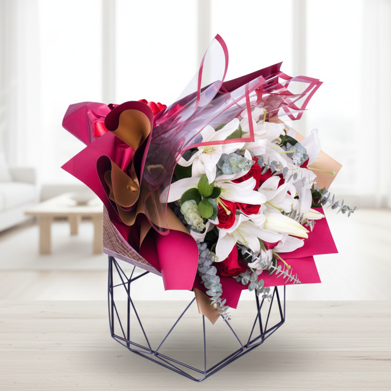 Elegant bouquet of white lilies and red roses wrapped in Korean paper with ribbon, perfect for delivery in Medellín.