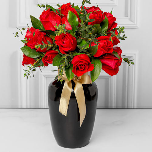 Luxury black vase with 36 red roses and seasonal foliage, available for delivery in Medellín and Bogotá