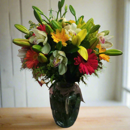 Orchid, gerberas and lilies in elegant glass vase – Flower delivery in Medellin