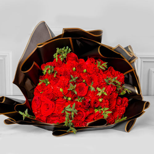 Bouquet of red roses and carnations wrapped in beautiful black Korean paper, available for delivery in Medellín and Bogotá