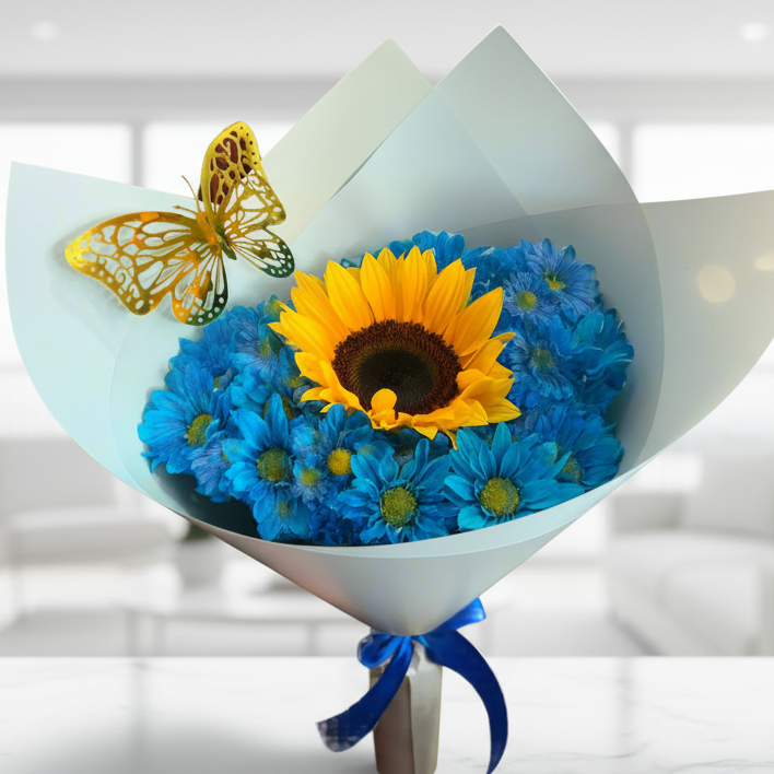 Bouquet with sunflower surrounded by blue daisies, gold butterfly, and blue ribbon – Acacías, Meta