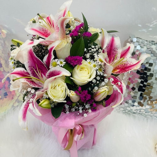 Crystal vase filled with pink lilies and white roses