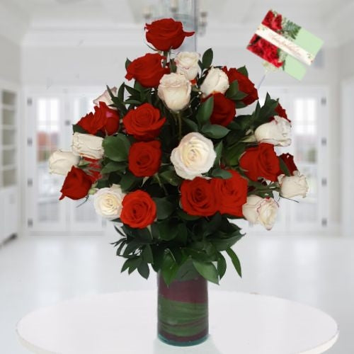 Two dozen red and white roses in glass vase