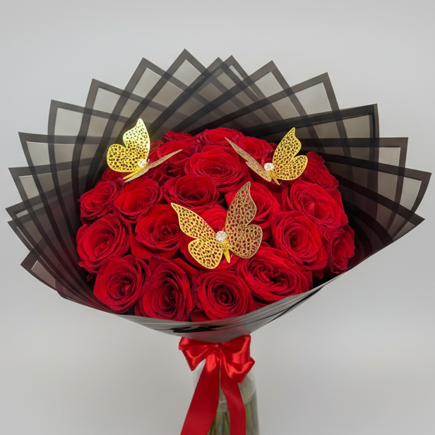 Premium bouquet of 24 red roses decorated with large golden butterflies, wrapped in elegant black floral paper with red bow, available for delivery in Medellín, Colombia.