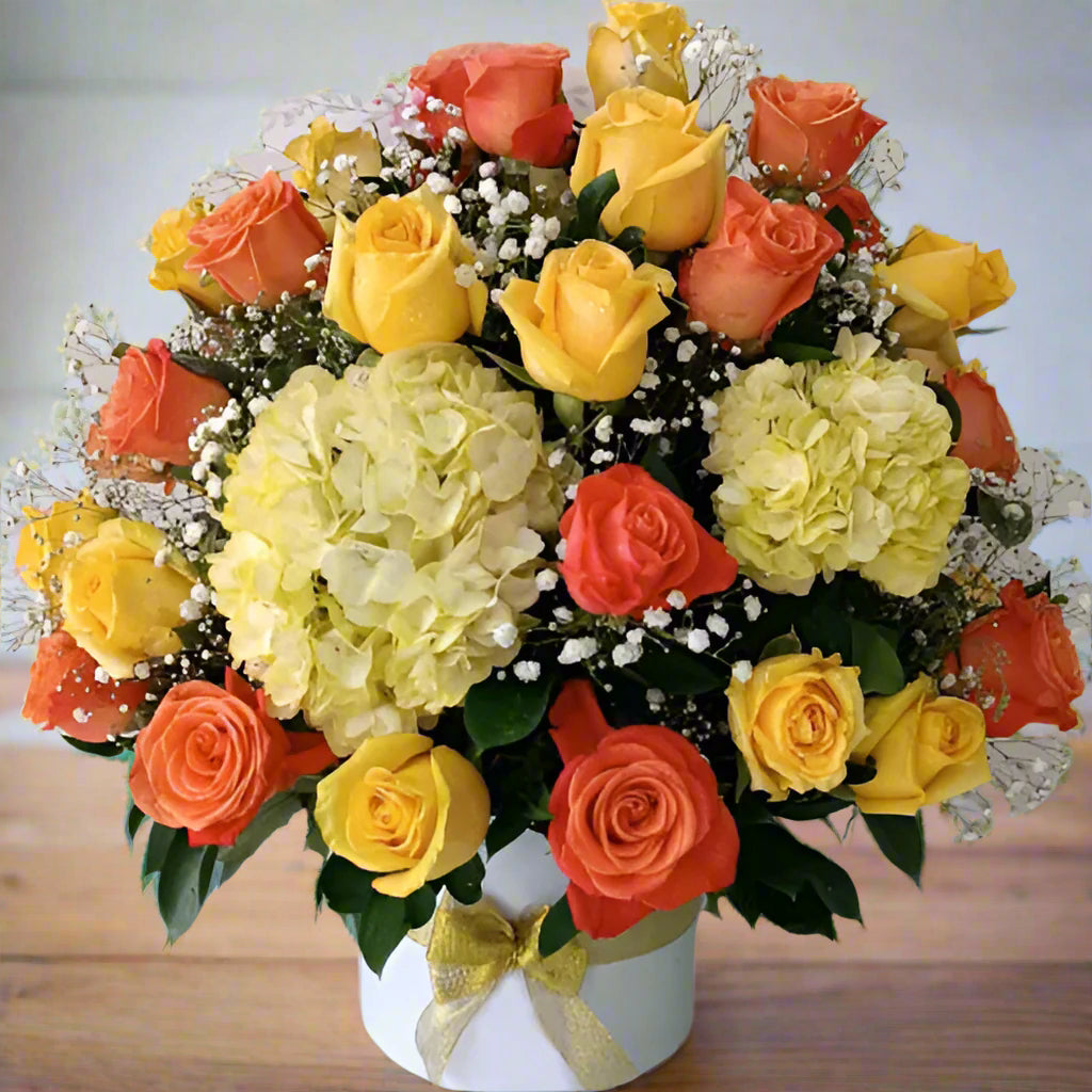 Arrangement of 50 yellow and orange roses with hydrangeas in a box, available for delivery in Bogotá, Medellín, Cúcuta, Pereira, and Cali