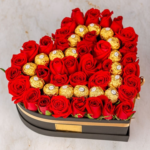 Heart of roses. Love in bloom, arrangement in red roses in a heart shape with chocolates,
