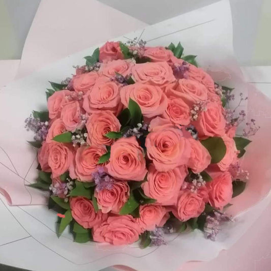 Elegant bouquet of pink roses with delicate baby’s breath and greenery, beautifully wrapped in pastel pink paper. Available for delivery in Cartago, Valle
