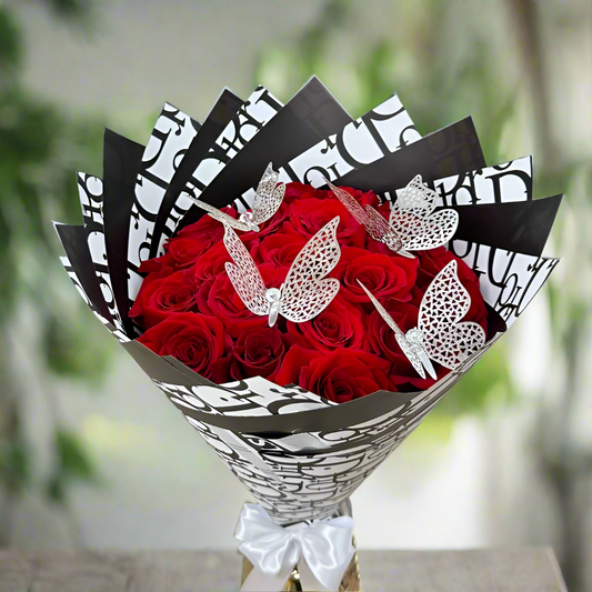 Bouquet of red roses with decorative paper and butterflies in a living room setting.