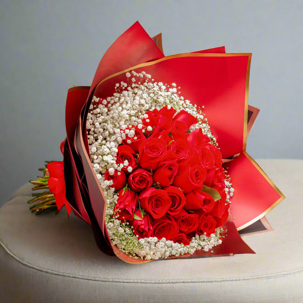 Bouquet of 36 premium red roses with gypsophila, wrapped in luxurious imported paper and tied with a red ribbon, perfect for Valentine’s Day in Medellín.