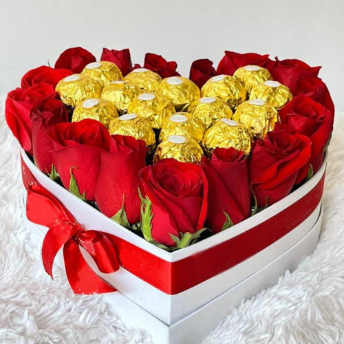 Heart-shaped white box with 16 Ferrero chocolates and 16 red roses, decorated with a bow – delivery available across Colombia