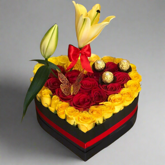 Heart-shaped box with yellow and red roses, lilies, Ferrero Rocher chocolates, and butterfly decoration – Same-day delivery in Acacías, Meta