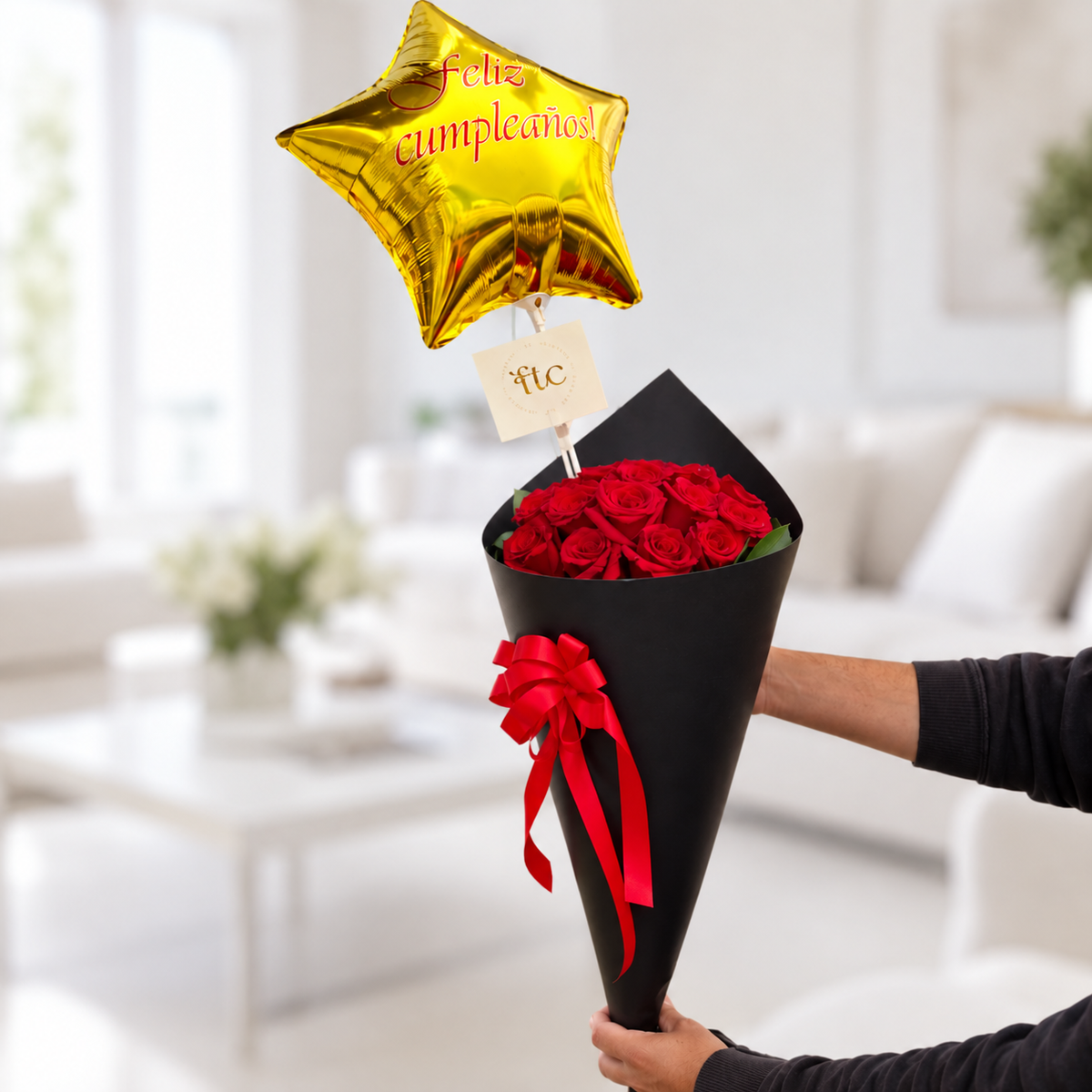 Bouquet of 18 red roses wrapped in elegant black cone paper with a red satin bow and gold Happy Birthday star balloon for delivery in Manizales, Colombia.
