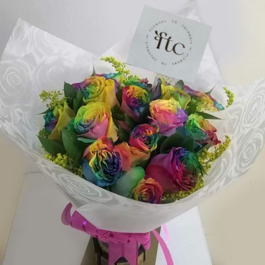 Beautiful bouquet of vibrant rainbow roses with delicate greenery, elegantly wrapped for delivery in Cartago, Valle. 