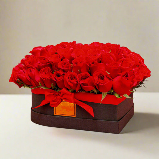 Luxury heart-shaped black box with 100 red roses arranged in a circular design, adorned with a red ribbon, perfect for Valentine’s Day in Medellín.