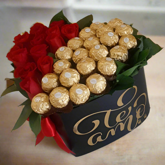 Luxury gift box with fresh red roses and Ferrero Rocher chocolates arranged in a black box with 'Te Amo' written in gold lettering, tied with a red ribbon – perfect for romantic occasions and same-day delivery in Cali