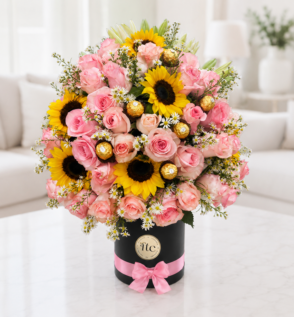 Luxury flower box with pink roses, sunflowers, white lilies, Ferrero Rocher chocolates, and seasonal flowers for same-day flower delivery in Restrepo, Meta.