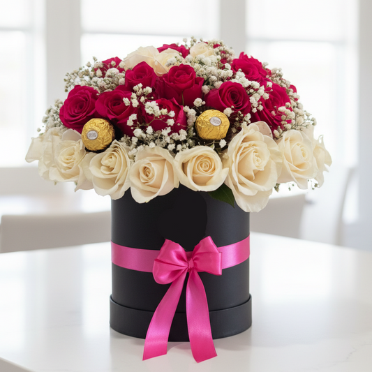 Luxury flower box with pink and white roses, Ferrero Rocher chocolates, baby's breath, and a black hat box with a pink ribbon for same-day flower delivery in Restrepo, Meta.