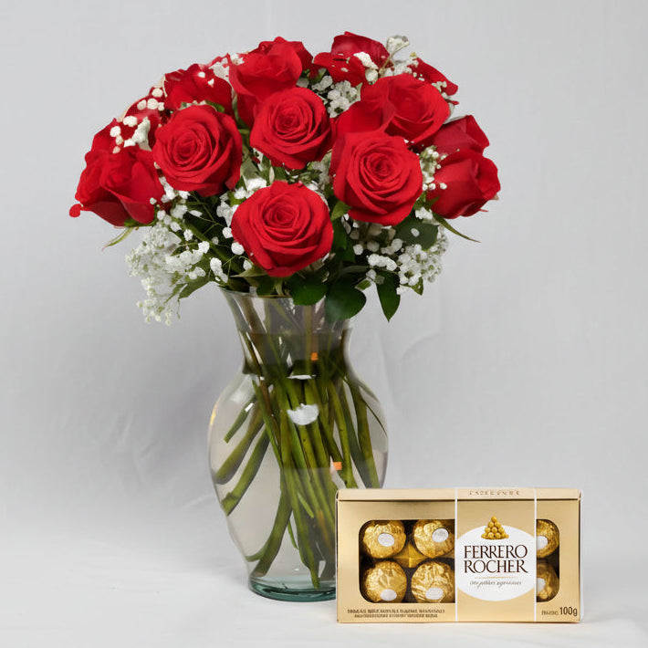 Red roses arrangement in glass vase with Ferrero Rocher chocolates, elegant flower delivery in Medellín.