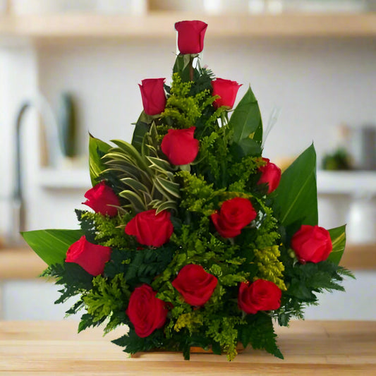triangular arrangement of fresh red roses with lush greenery, perfect for anniversaries, birthdays, or romantic gestures. Available for delivery in Cali, Bogotá, Cúcuta and more.
