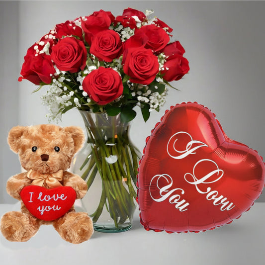 Red roses arrangement in glass vase with teddy bear and “I Love You” heart balloon, romantic flower delivery in Medellín.