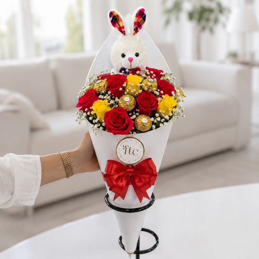 Luxury bouquet with premium red and yellow roses, Ferrero Rocher chocolates, baby's breath, and a plush bunny in an elegant cone wrap for same-day flower delivery in Restrepo, Meta.