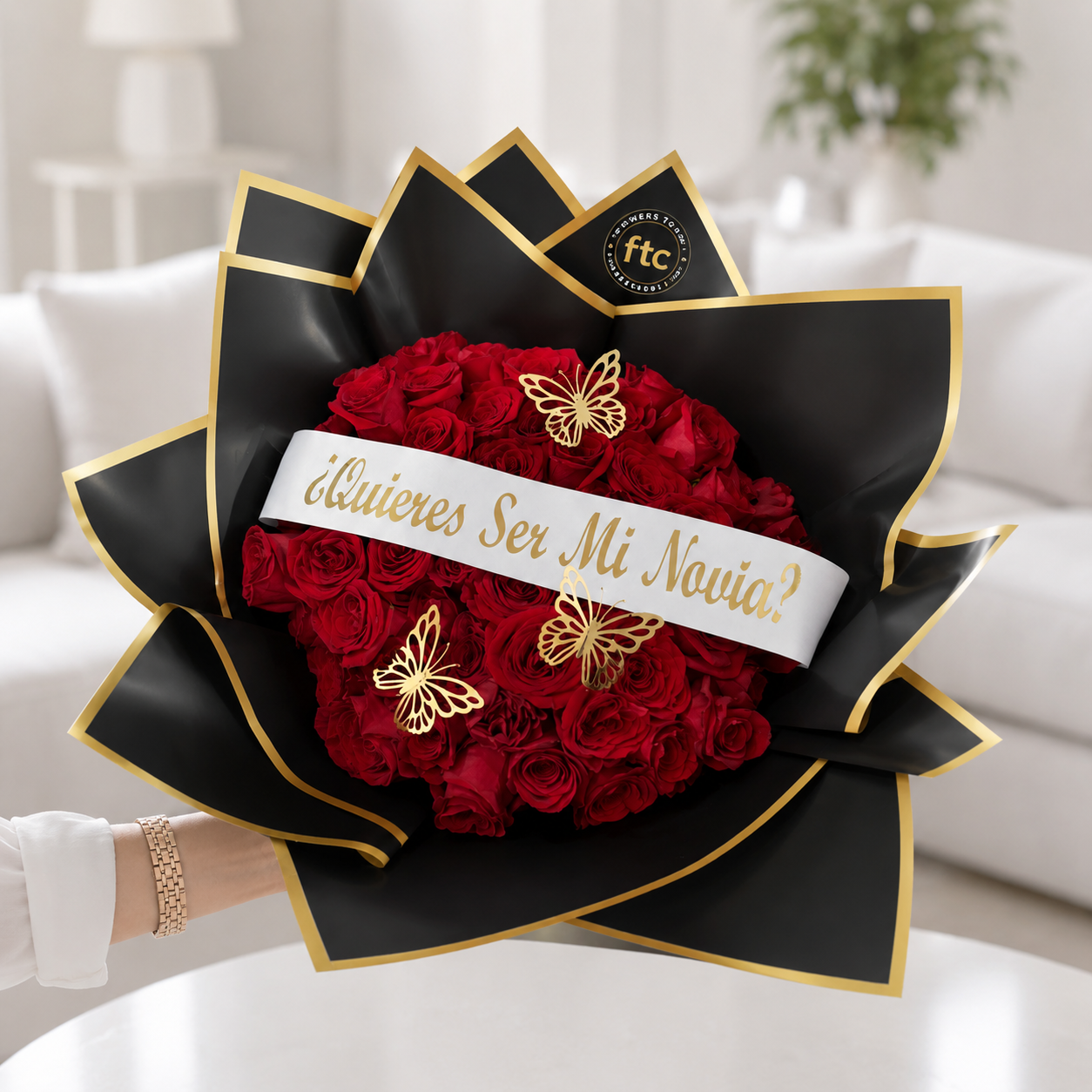 Luxury bouquet of premium red roses wrapped in elegant black and gold paper with a "Will You Be My Girlfriend?" ribbon and decorative butterflies for same-day flower delivery in Restrepo, Meta.