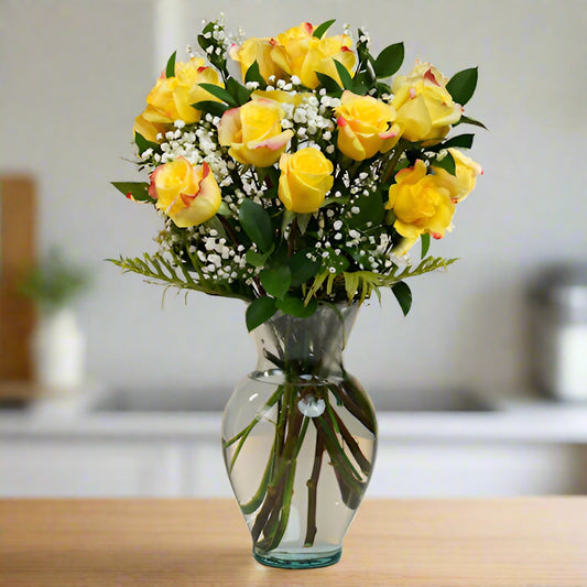Radiant bouquet of 12 to 36 yellow roses in a transparent vase, symbolizing joy and friendship.